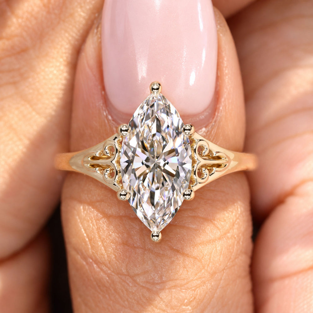 Marquise diamond ring with ornate scroll detailing.
