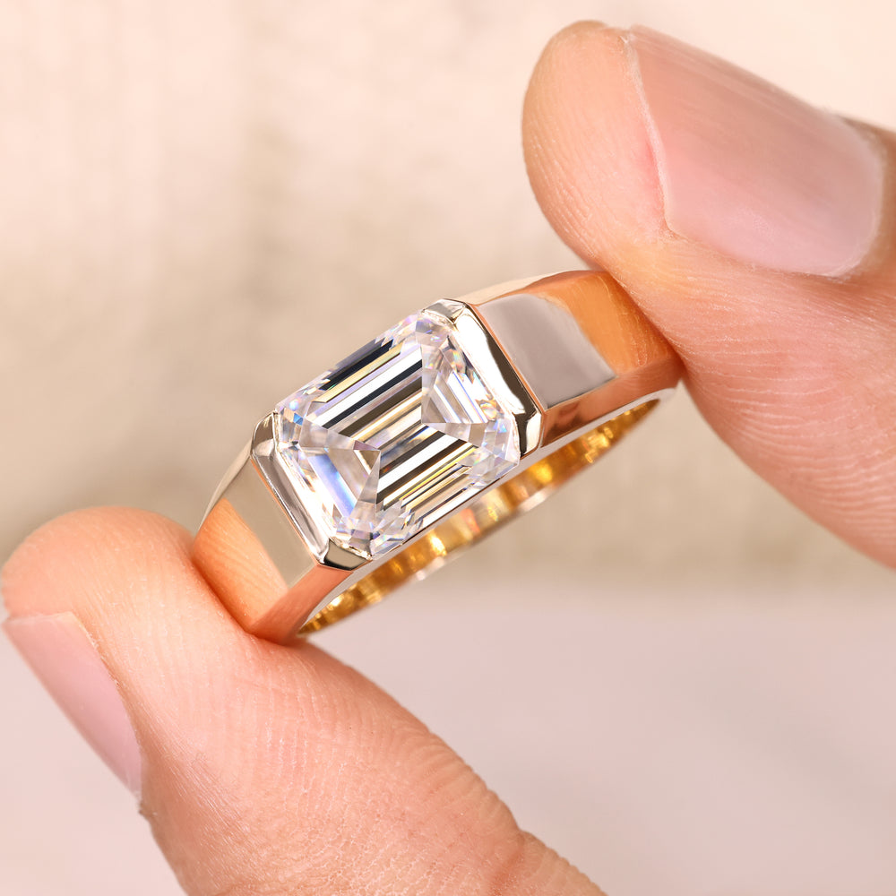 Solitaire emerald ring with tapered shank design.
