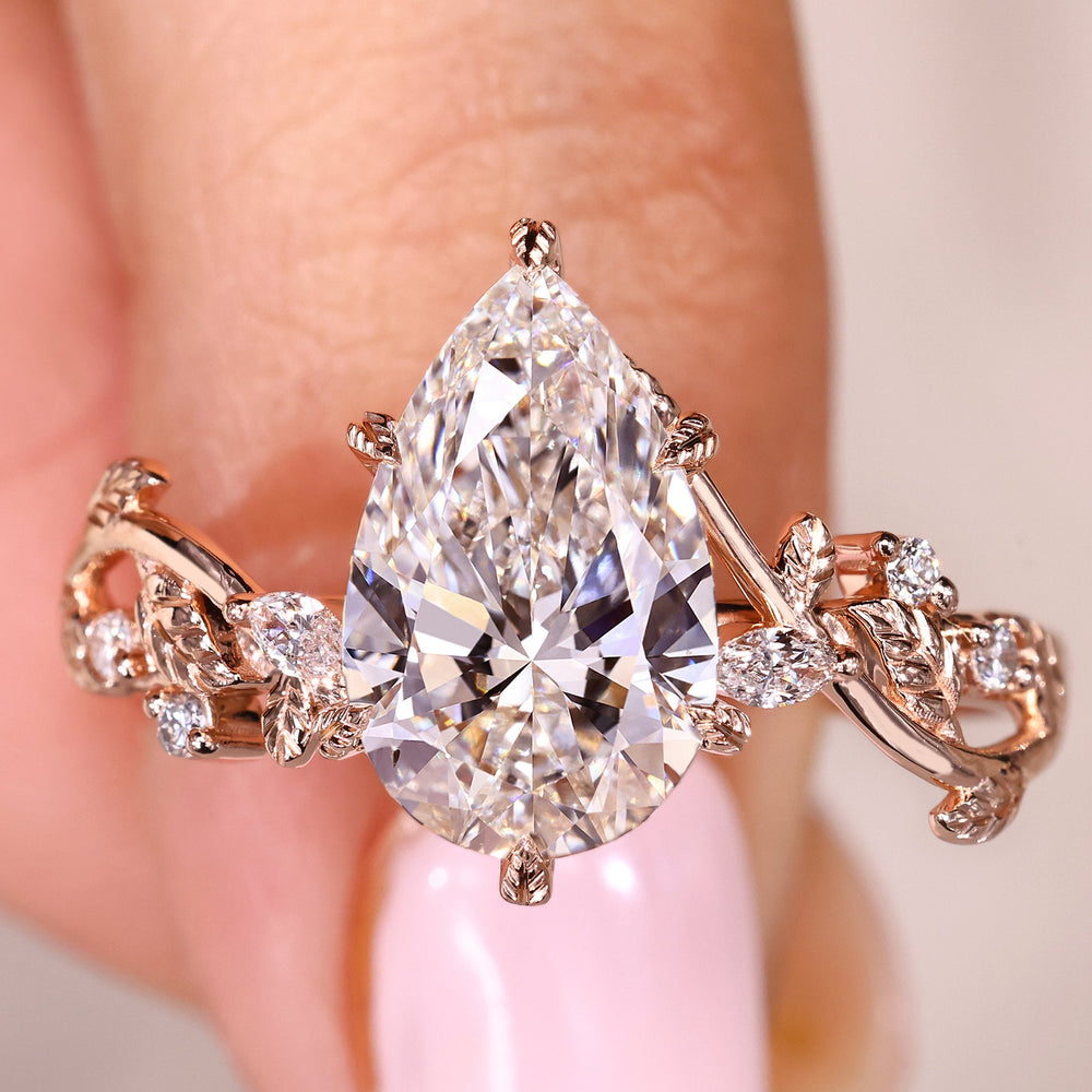 Pear shaped diamond ring with marquise and round side stones
