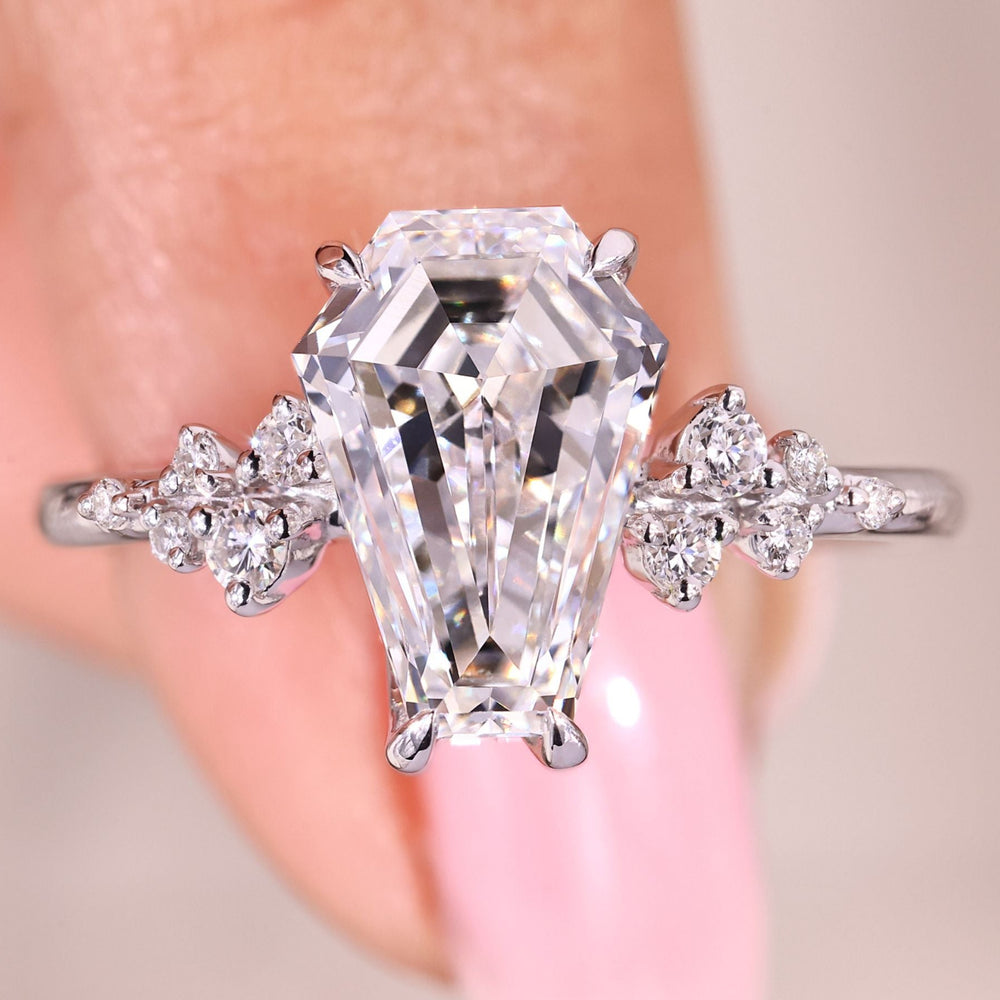 Coffin cut diamond engagement ring with round side stones.