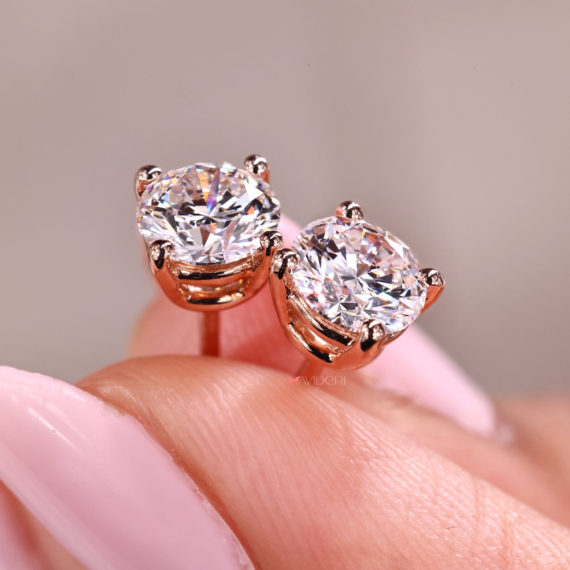 Solitaire diamond earrings in rose gold.