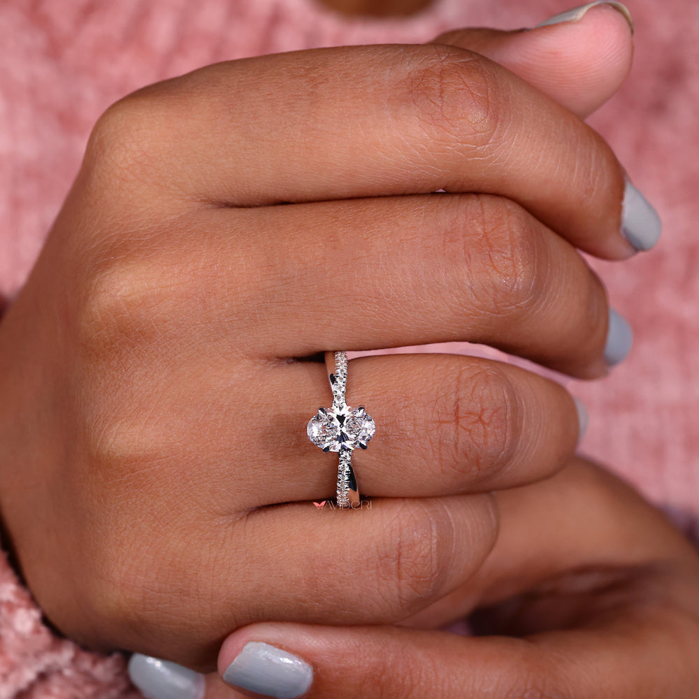 Handmade jewelry showcasing an oval twist engagement ring with four claw prongs and a pave setting design.
