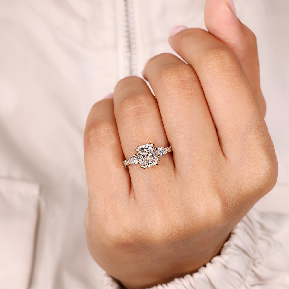 Cushion cut ring with pear side stone design.

