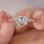 Radiant cut diamond engagement ring with pave round diamonds.