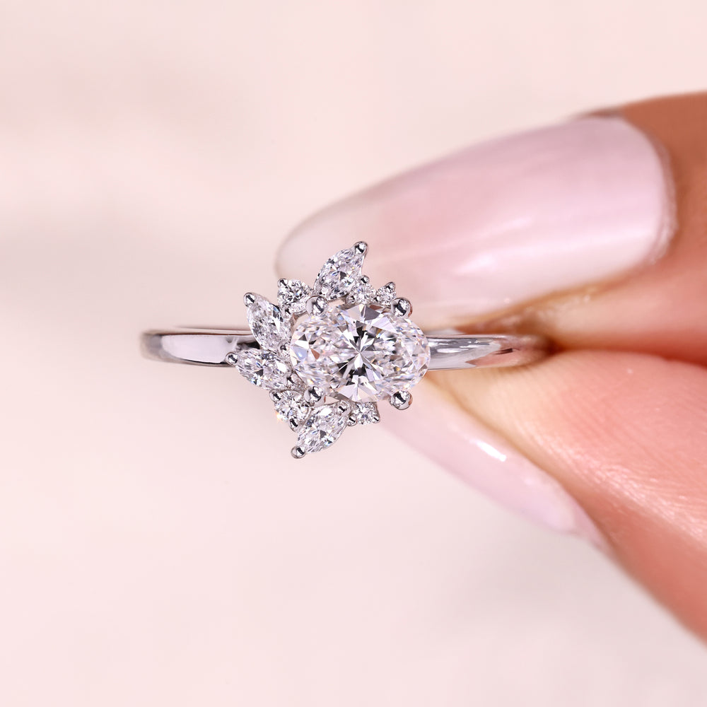 Oval cut diamond ring with east west cluster halo.
