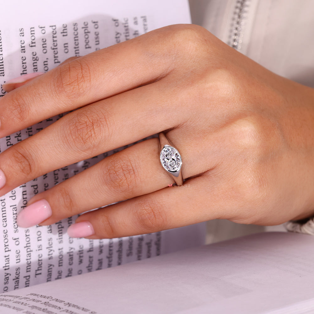 East to west oval diamond ring with sleek bezel setting.

