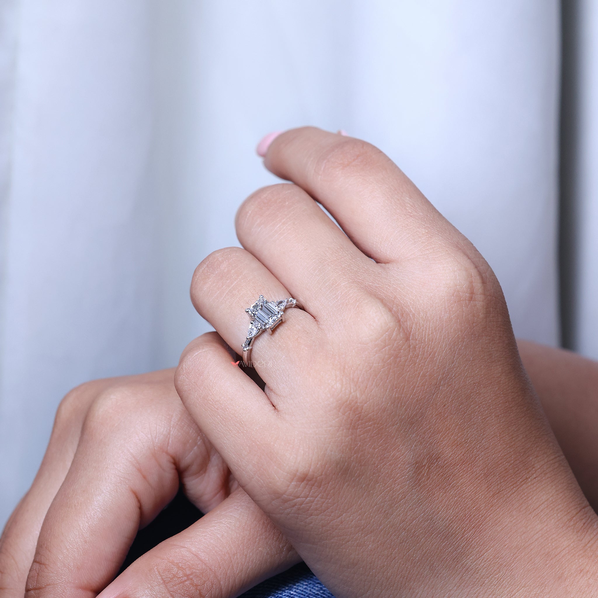 Prong setting ring made with emerald diamond and pear side diamonds for anniversary gifts for her.
