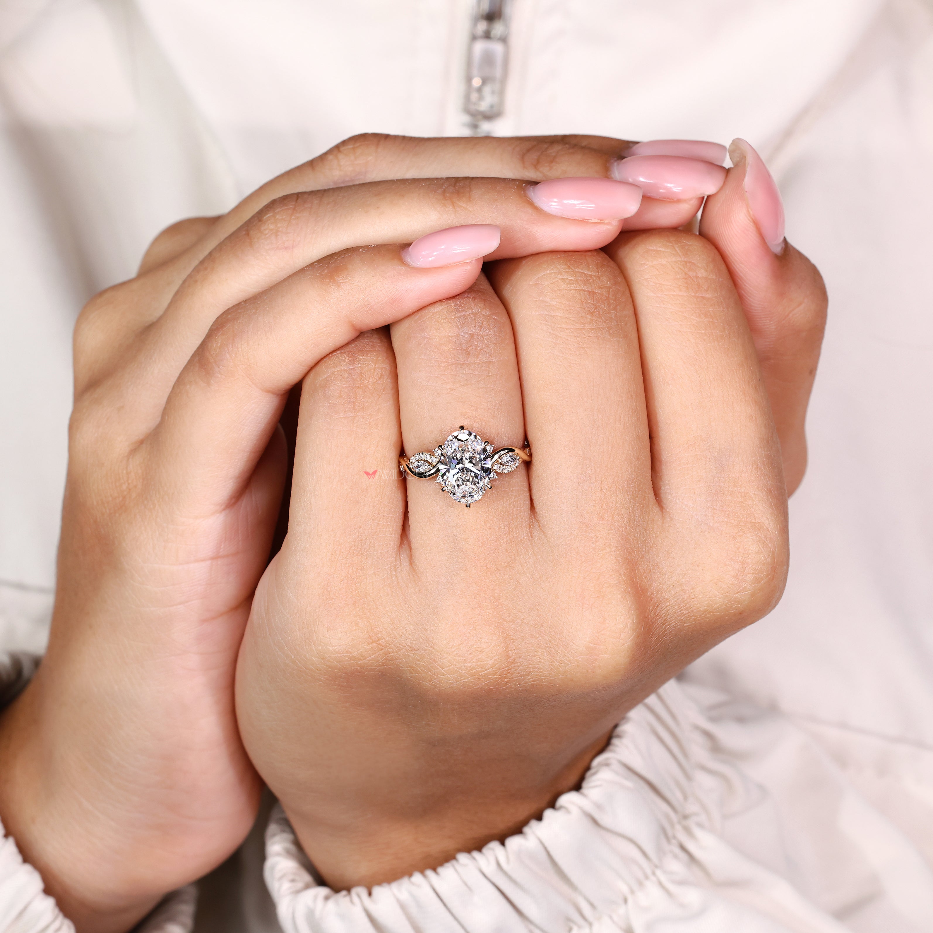 Oval diamond ring with six claw prongs and marquise stones
