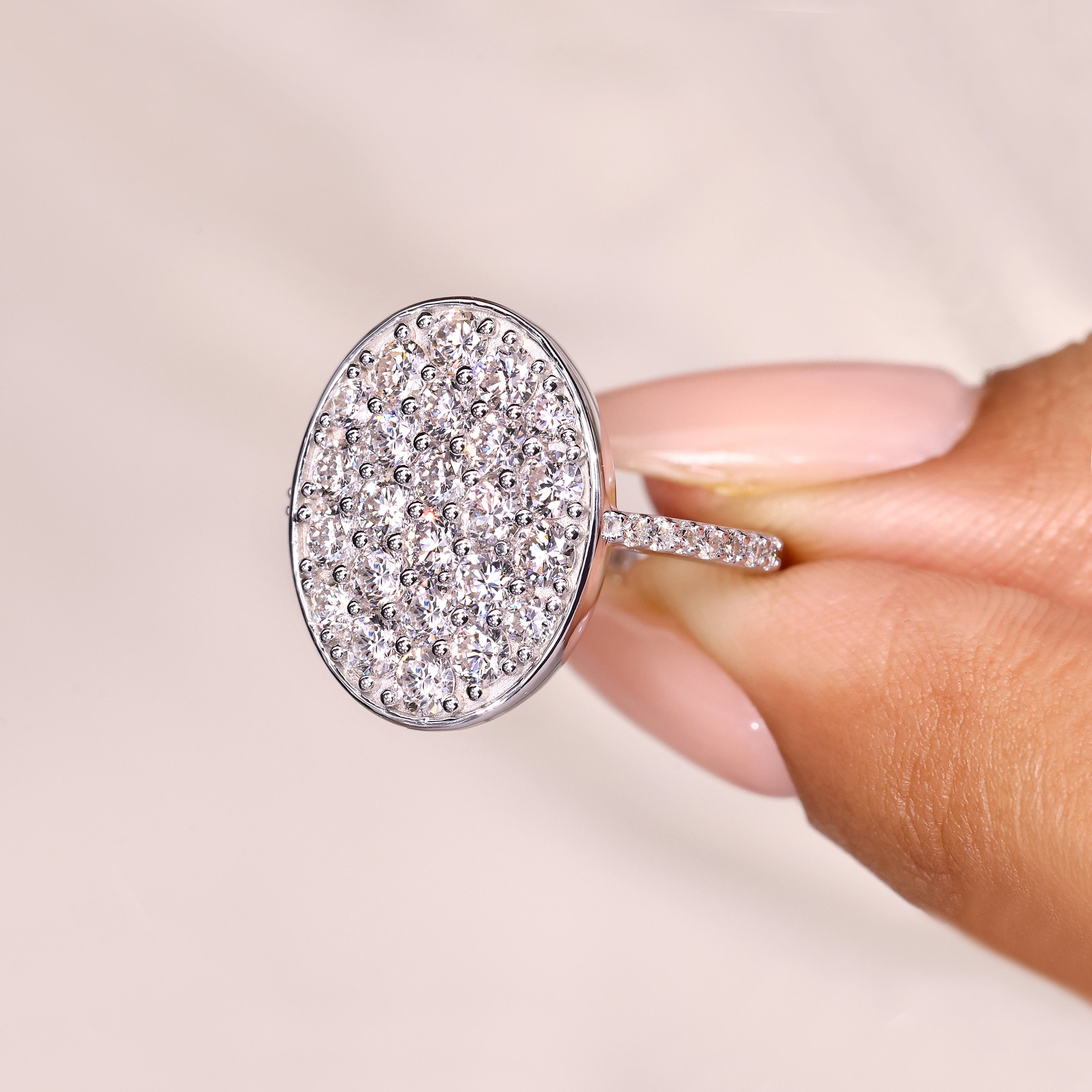Cluster engagement ring with round diamonds and oval outline.
