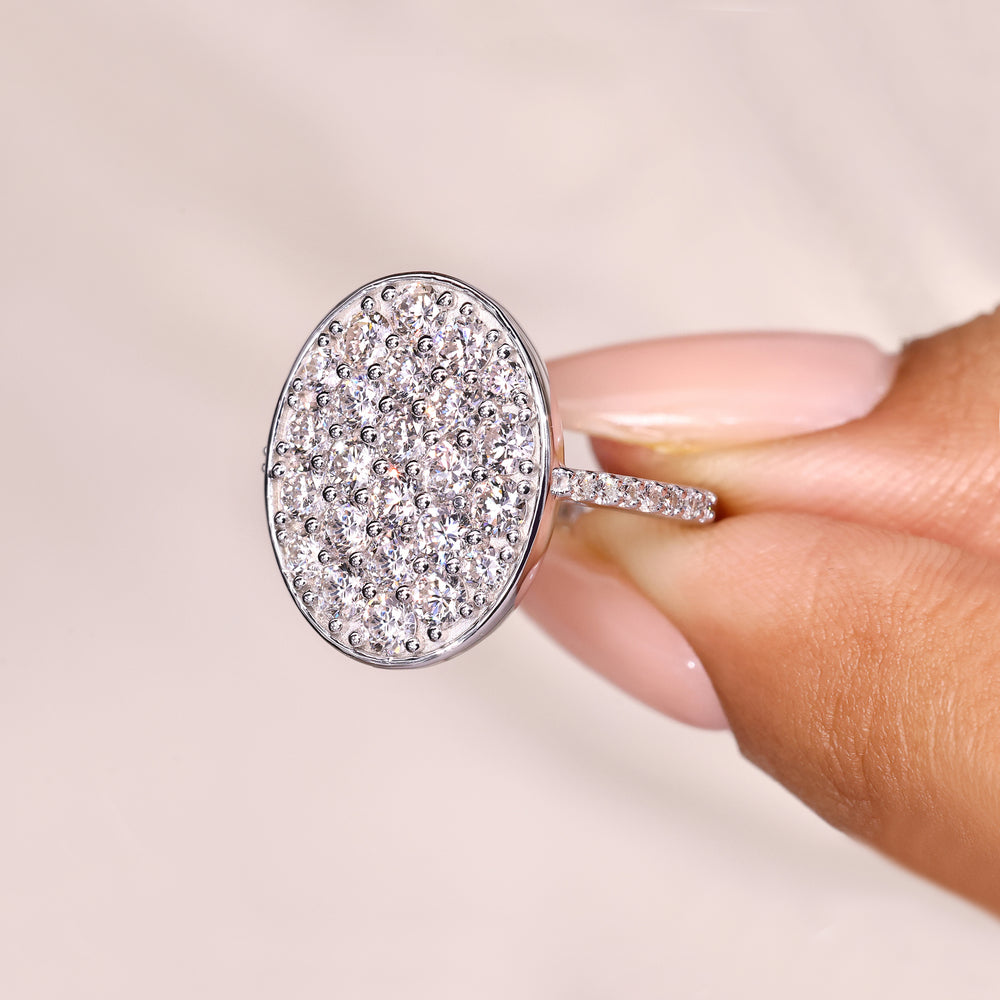 Cluster engagement ring with round diamonds and oval outline.
