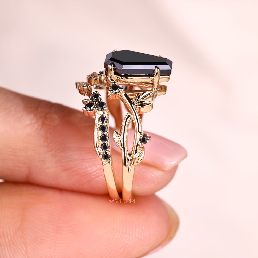 Five stone ring with black moissanite in a yellow gold bridal set.