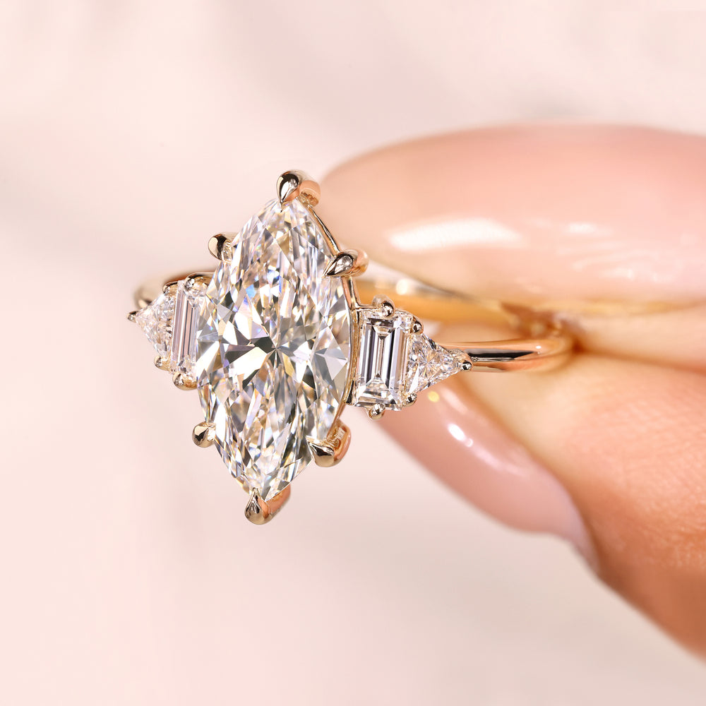 Marquise diamond engagement ring with triangle and baguette accents.
