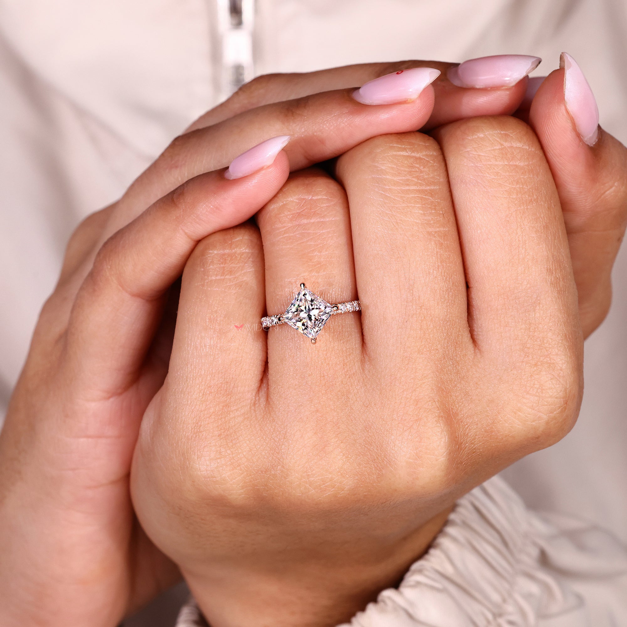 Modern engagement ring with square moissanite and compass prong design.