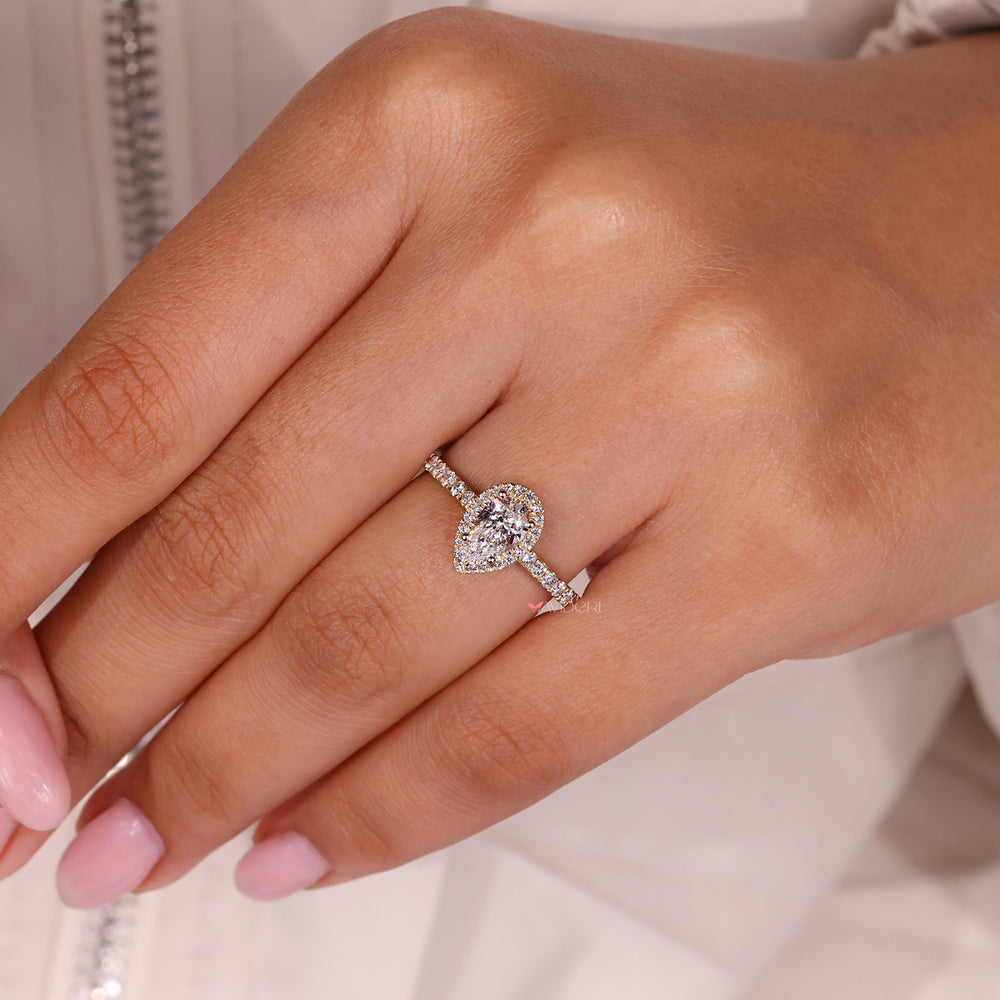 Yellow gold ring crafted with a pear halo engagement setting.
