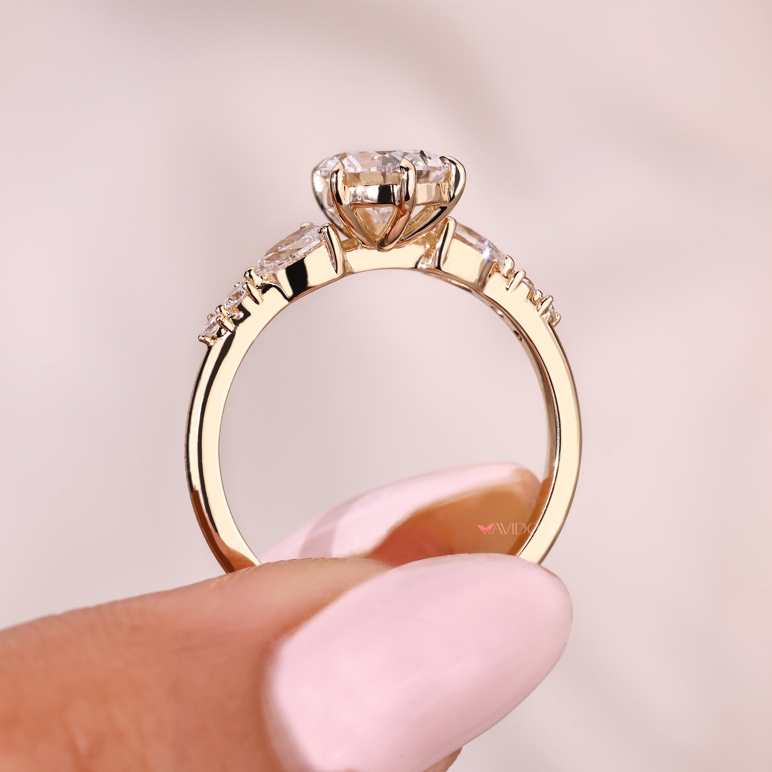 Pear diamond ring with round side stones and basket setting
