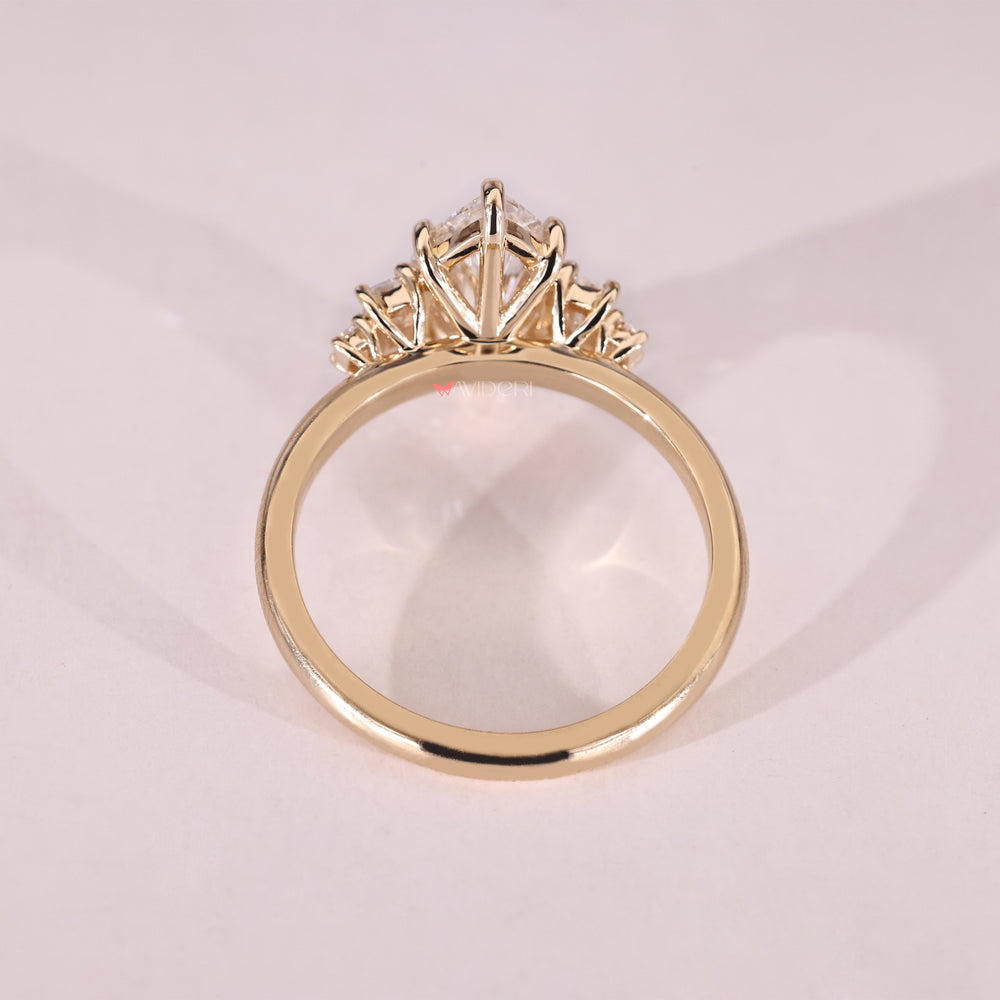 Five stone engagement ring featuring a marquise center and two baguette and round sides.

