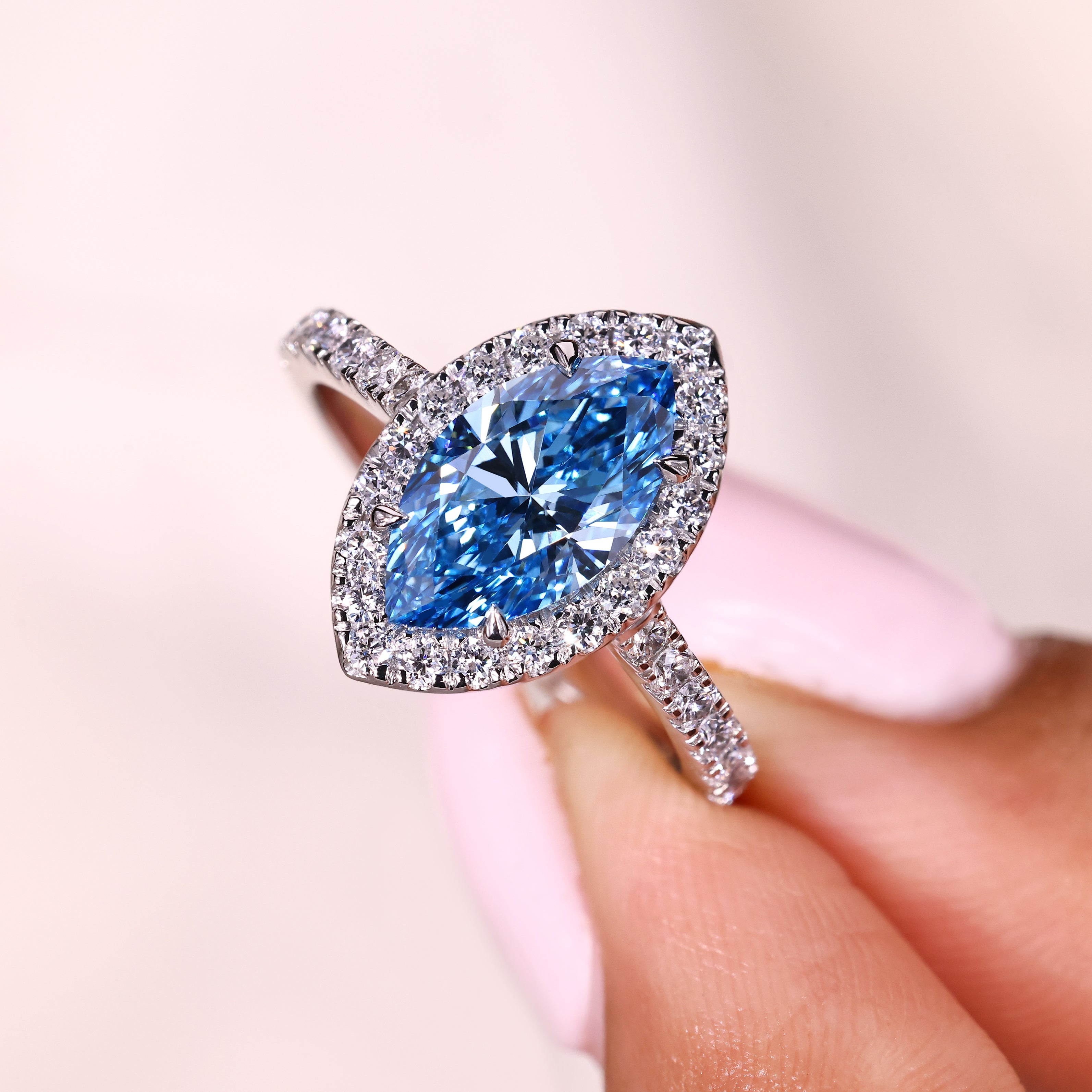 Marquise blue diamond ring with halo and pave details
