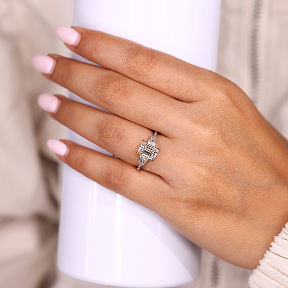 Handmade emerald cut ring with round side stone details
