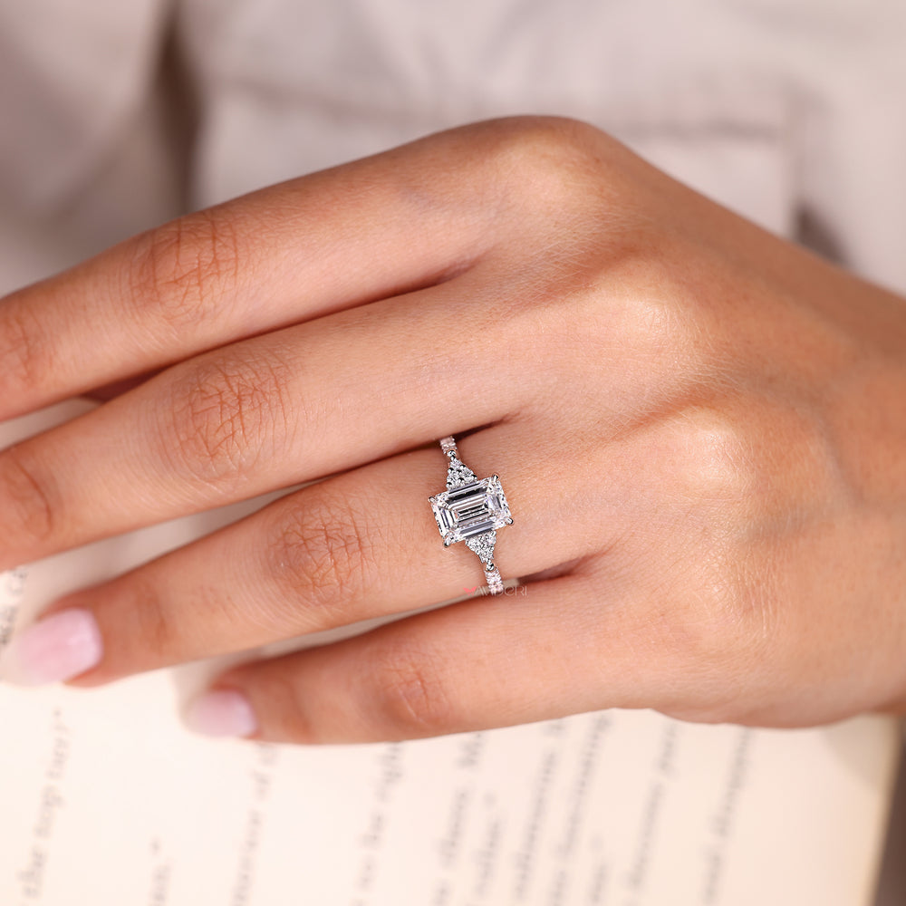 Emerald diamond ring with round pave accents.
