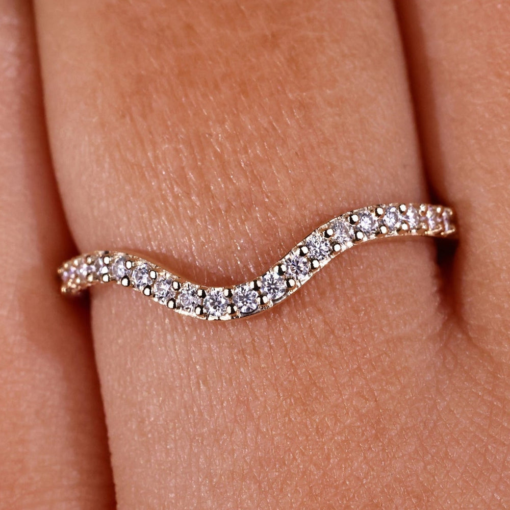 Curved diamond wedding band with sleek design and brilliant diamonds.
