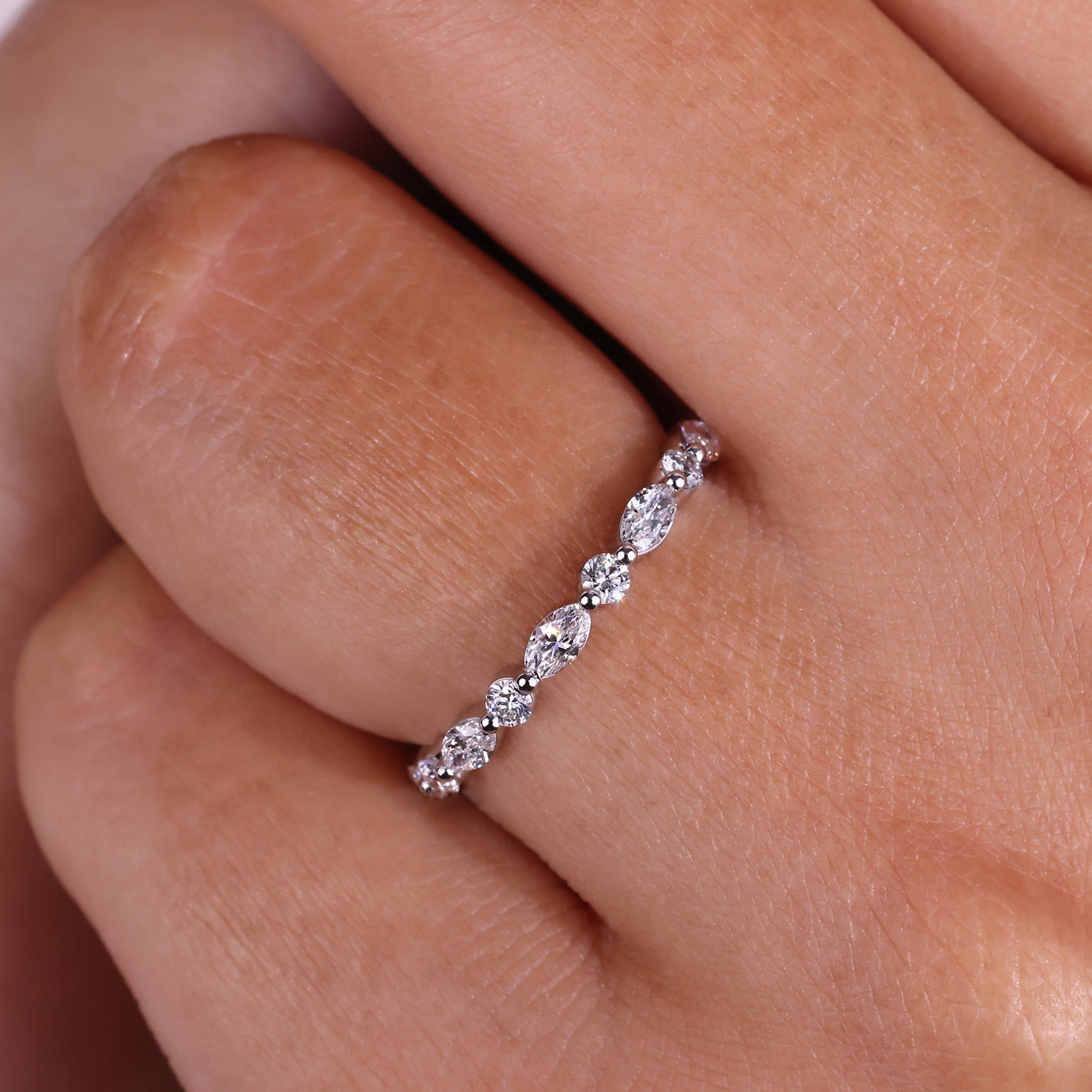 Elegant marquise and round wedding band designed with sparkling diamonds in a classic setting.
