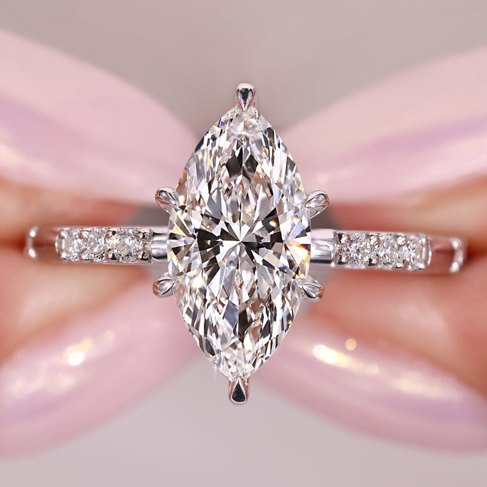 marquise diamond engagement ring with round diamond accents in white gold.