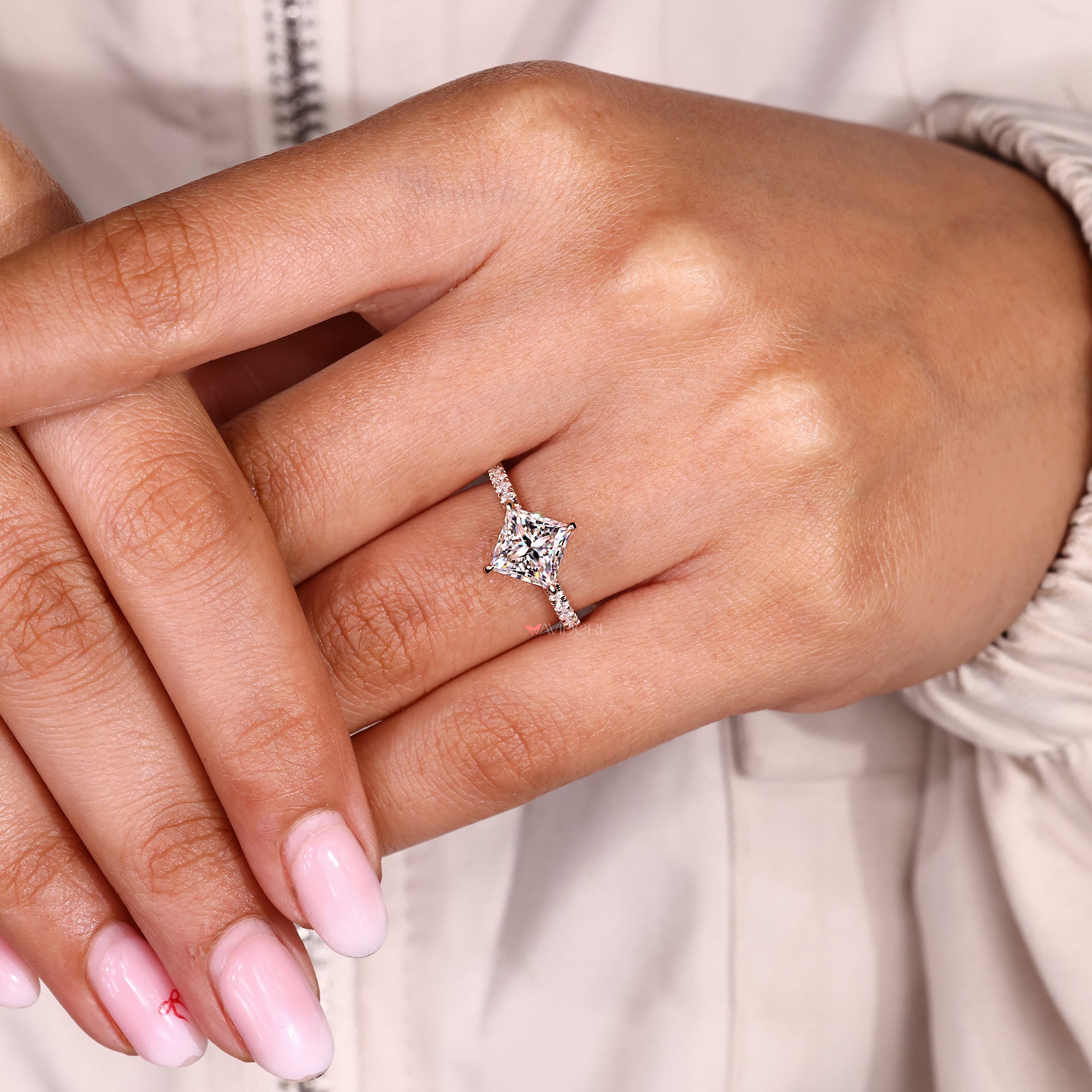 Designer engagement ring featuring a princess cut moissanite and pave band.