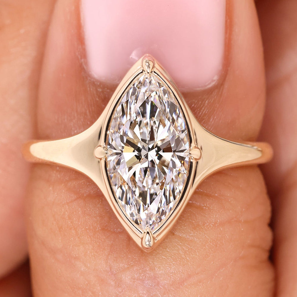 Marquise cut engagement ring with bezel type prong setting.