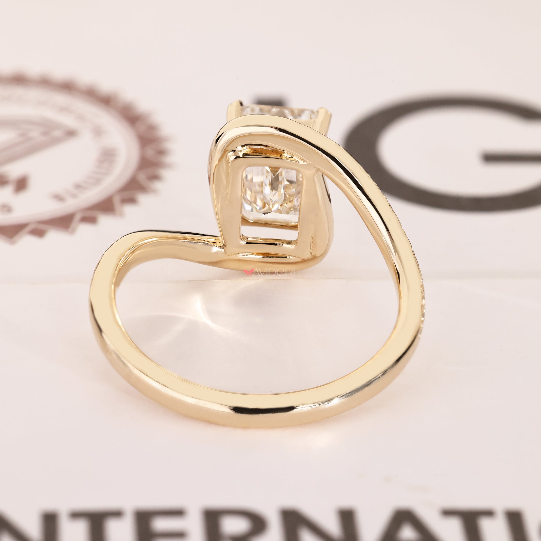 Emerald cut solitaire ring with leaf prongs.
