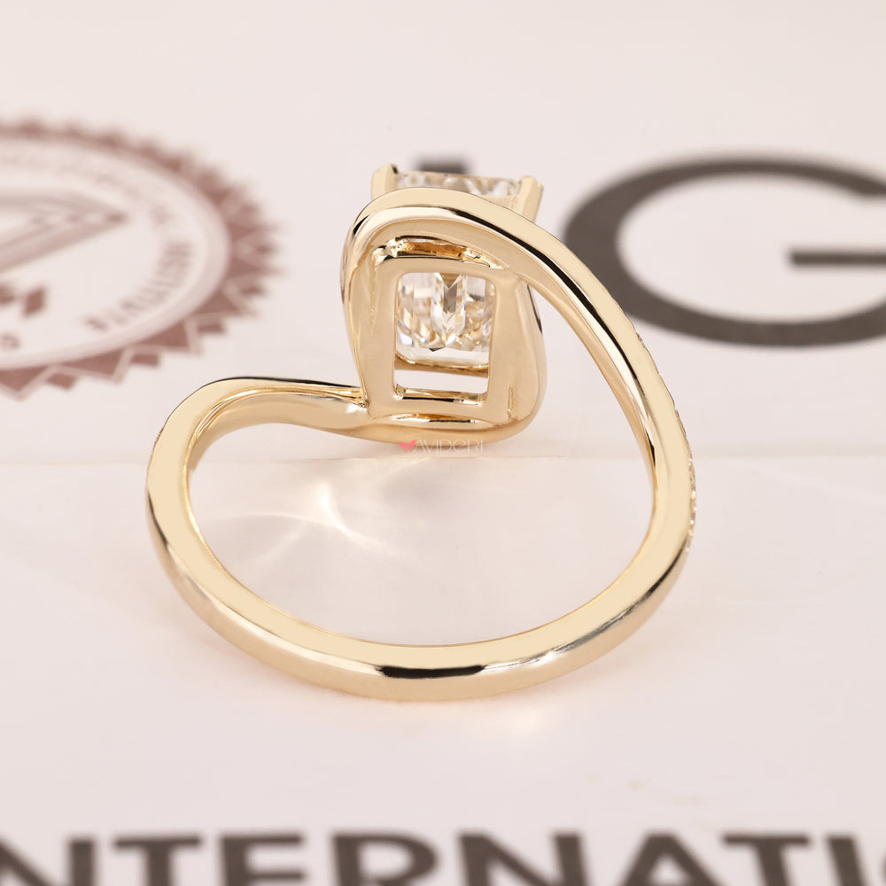 Emerald cut solitaire ring with leaf prongs.
