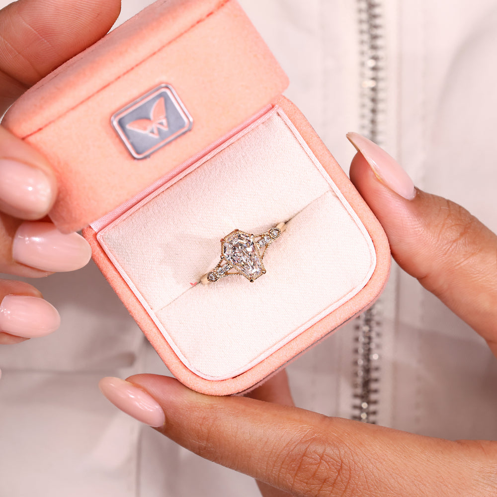 Elongated shield diamond ring with round accent stones.
