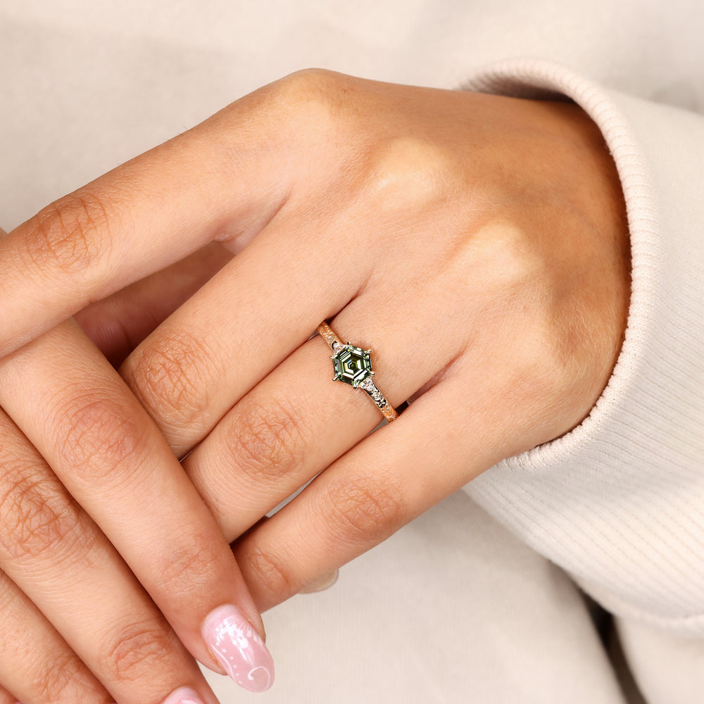 Hexagon diamond engagement ring with green diamond.
