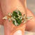 Oval green diamond engagement ring with twisted shank.