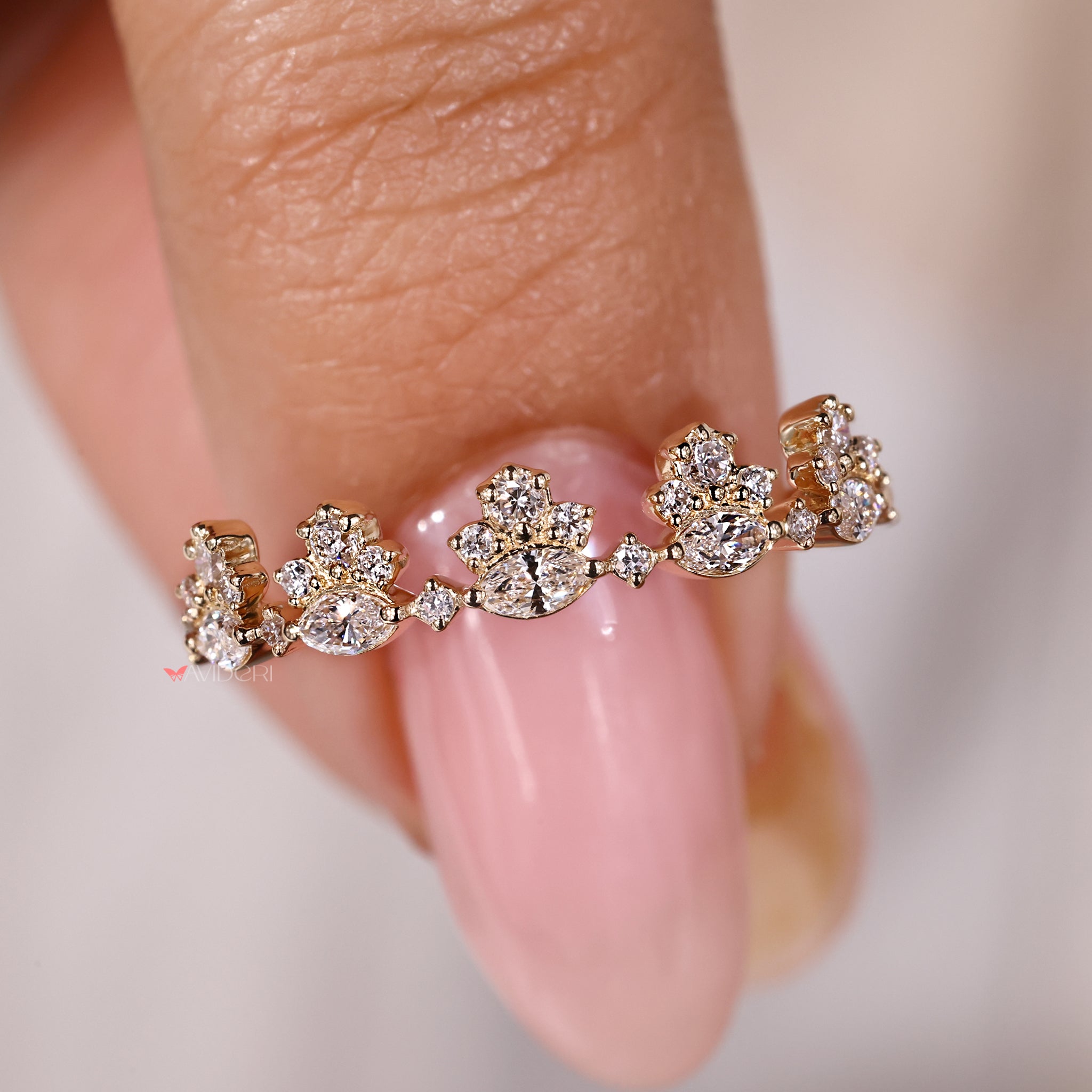 Crown wedding band combining marquise and round stones in a curved layout.
