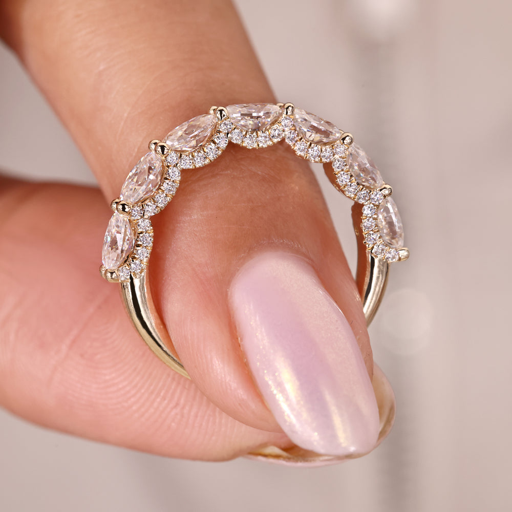 Oval cut moissanite wedding band crafted in yellow gold with a half eternity layout.