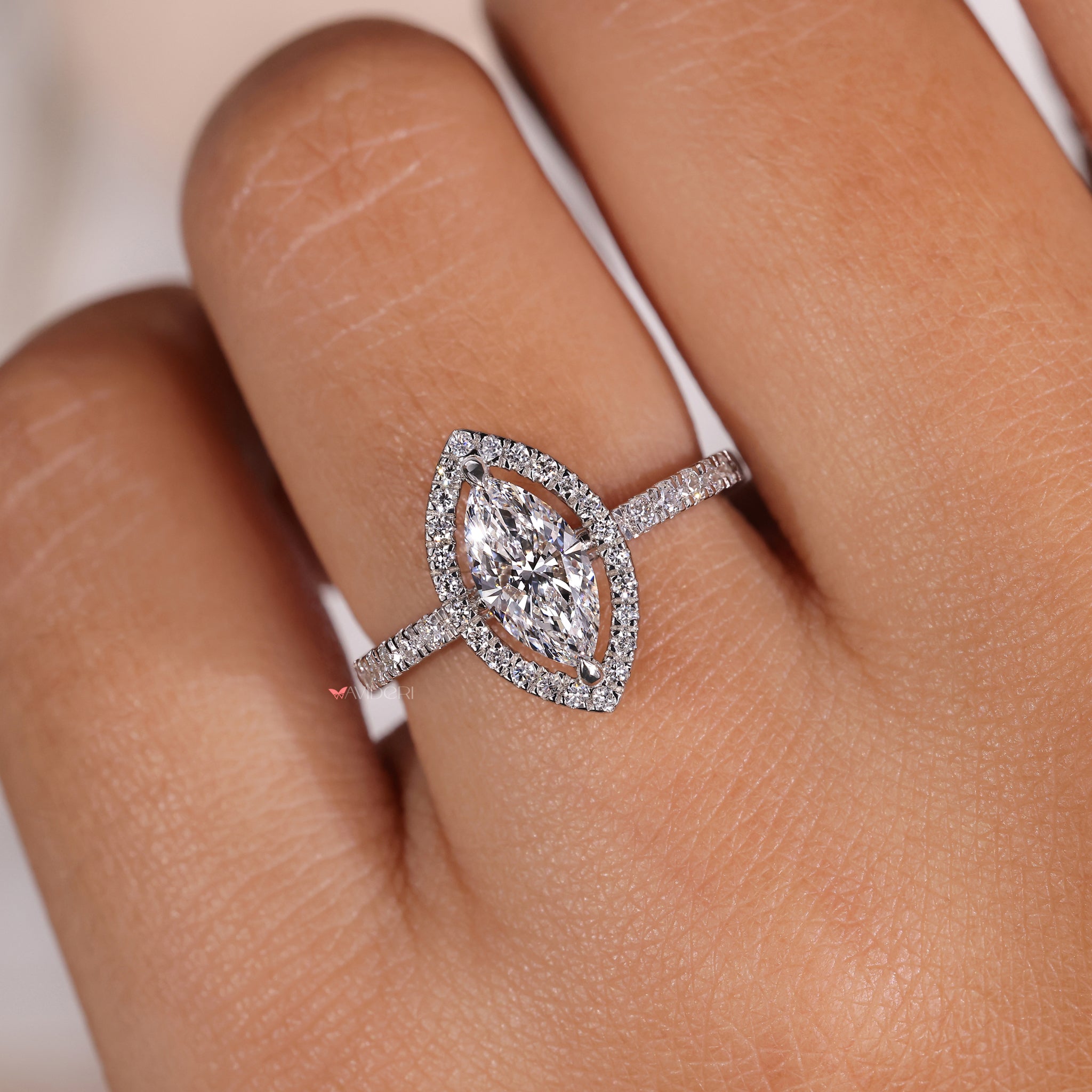 Marquise halo ring featuring pave diamond ring accents and a compass prong setting for added brilliance.
