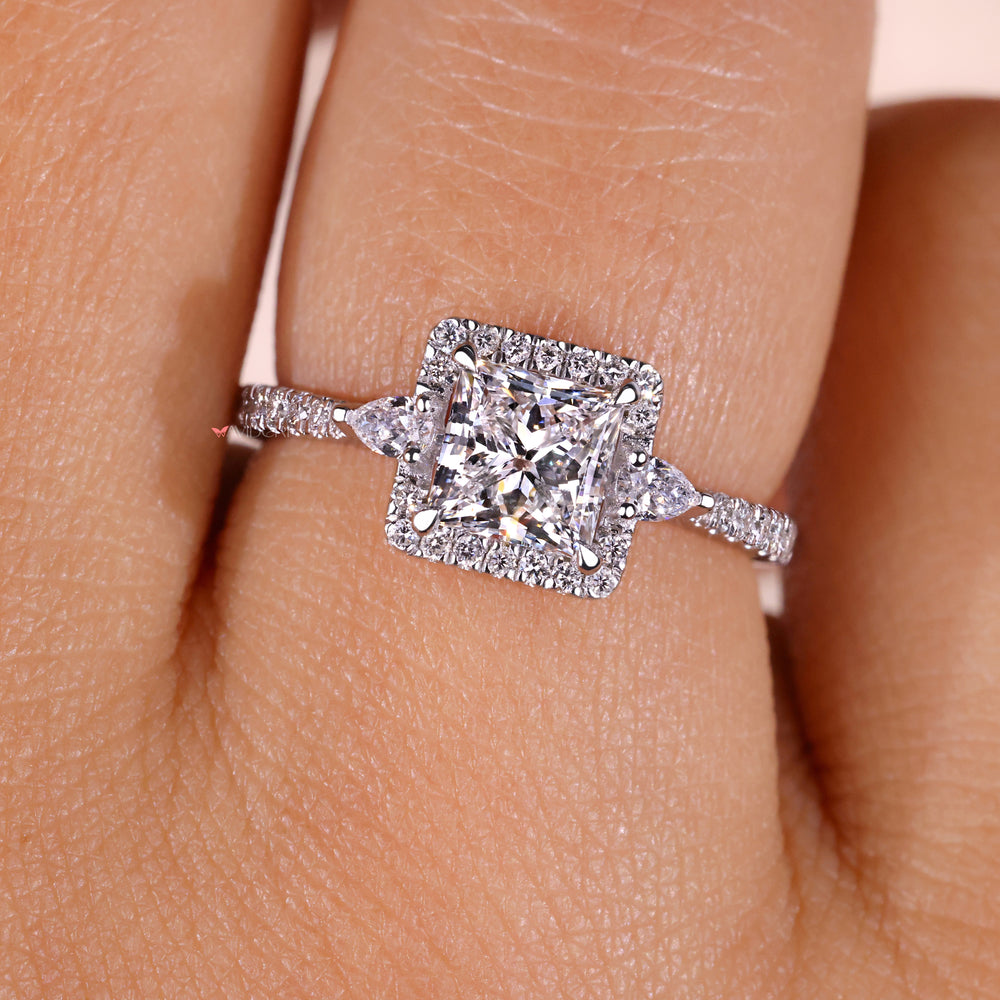 Engagement ring with 2 pear cut side stones and a central princess diamond, offering a unique and luxurious design.
