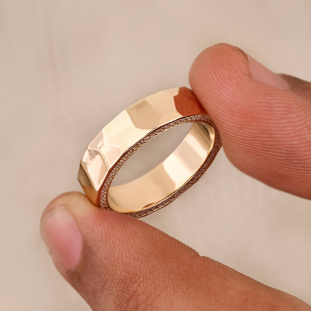 Hammered texture eternity band with round cut diamond details.
