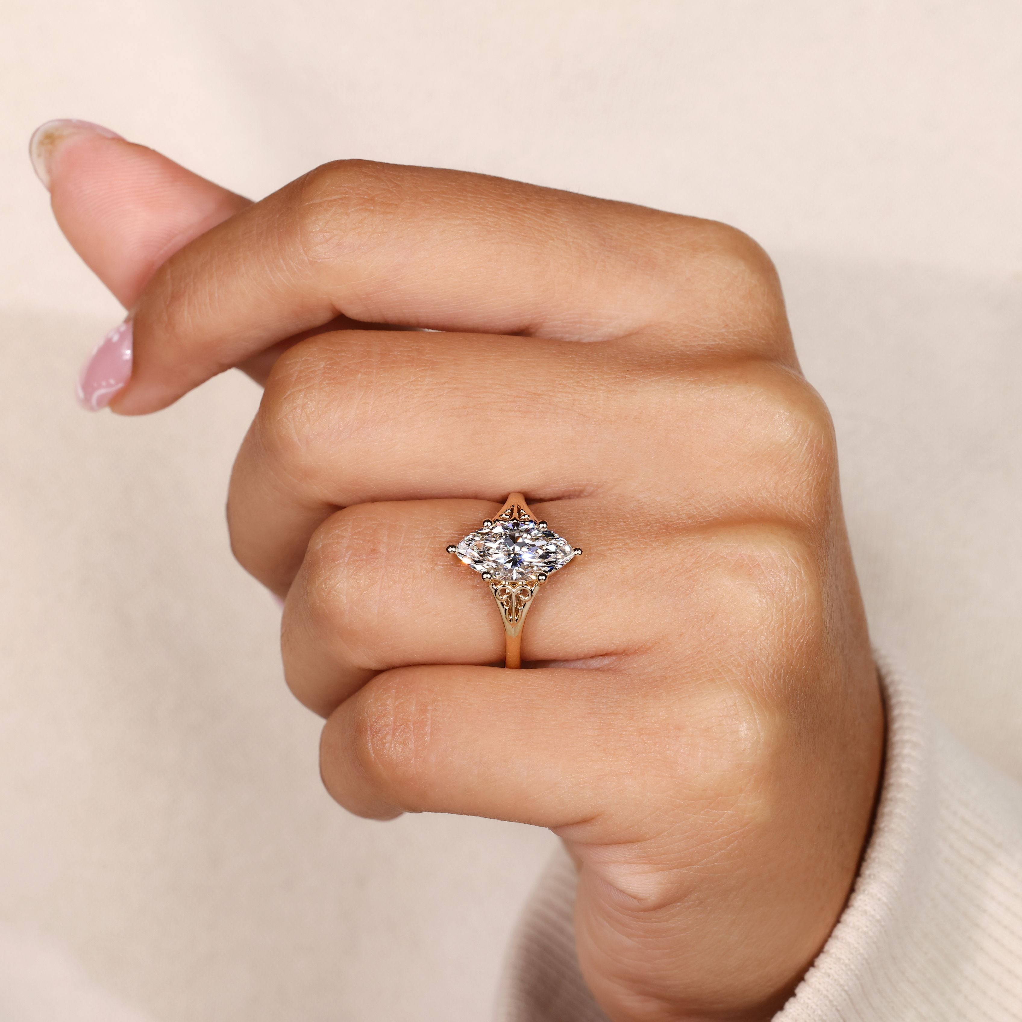 Solitaire marquise diamond ring with ornate details.
