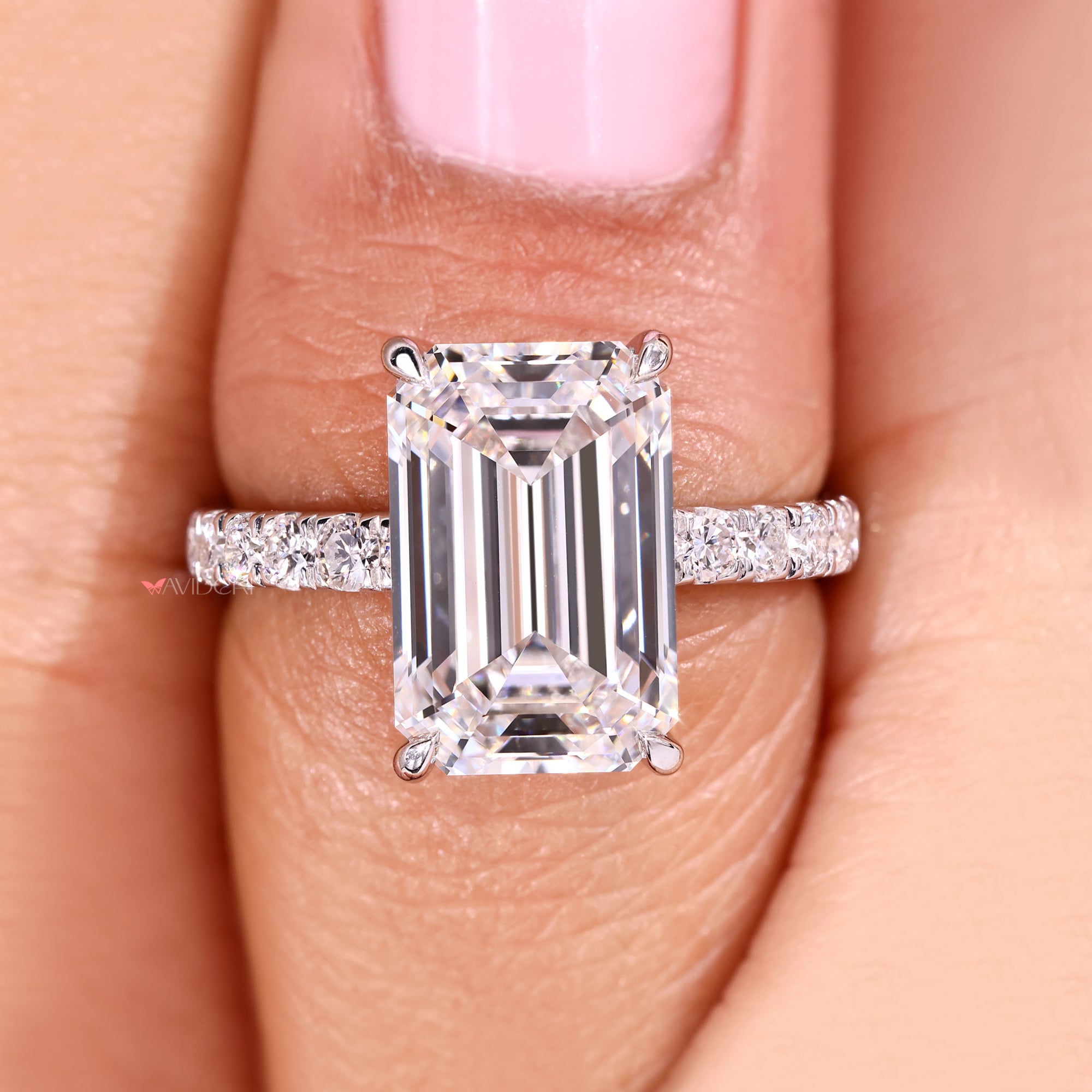 Lab grown emerald cut diamond ring with claw prongs.
