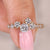Round diamond engagement ring with cluster setting.