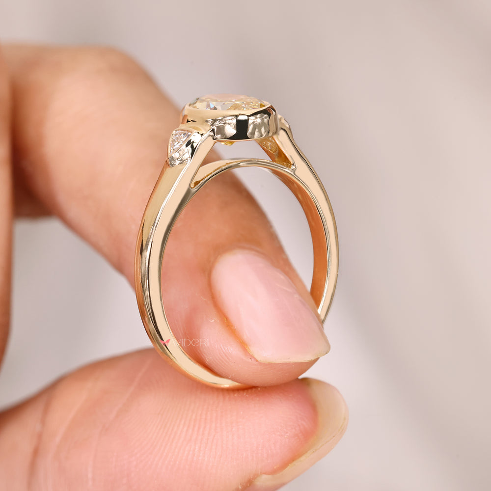 Oval ring with two trillion side stones design.
