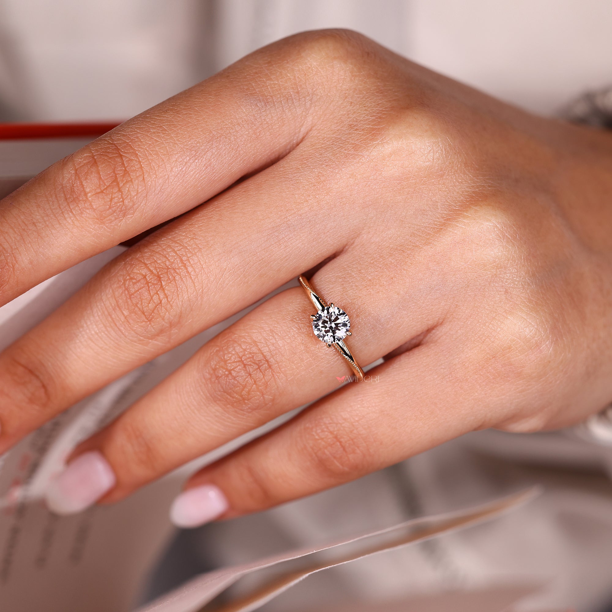 Solitaire round cut diamond ring with milgrain setting.
