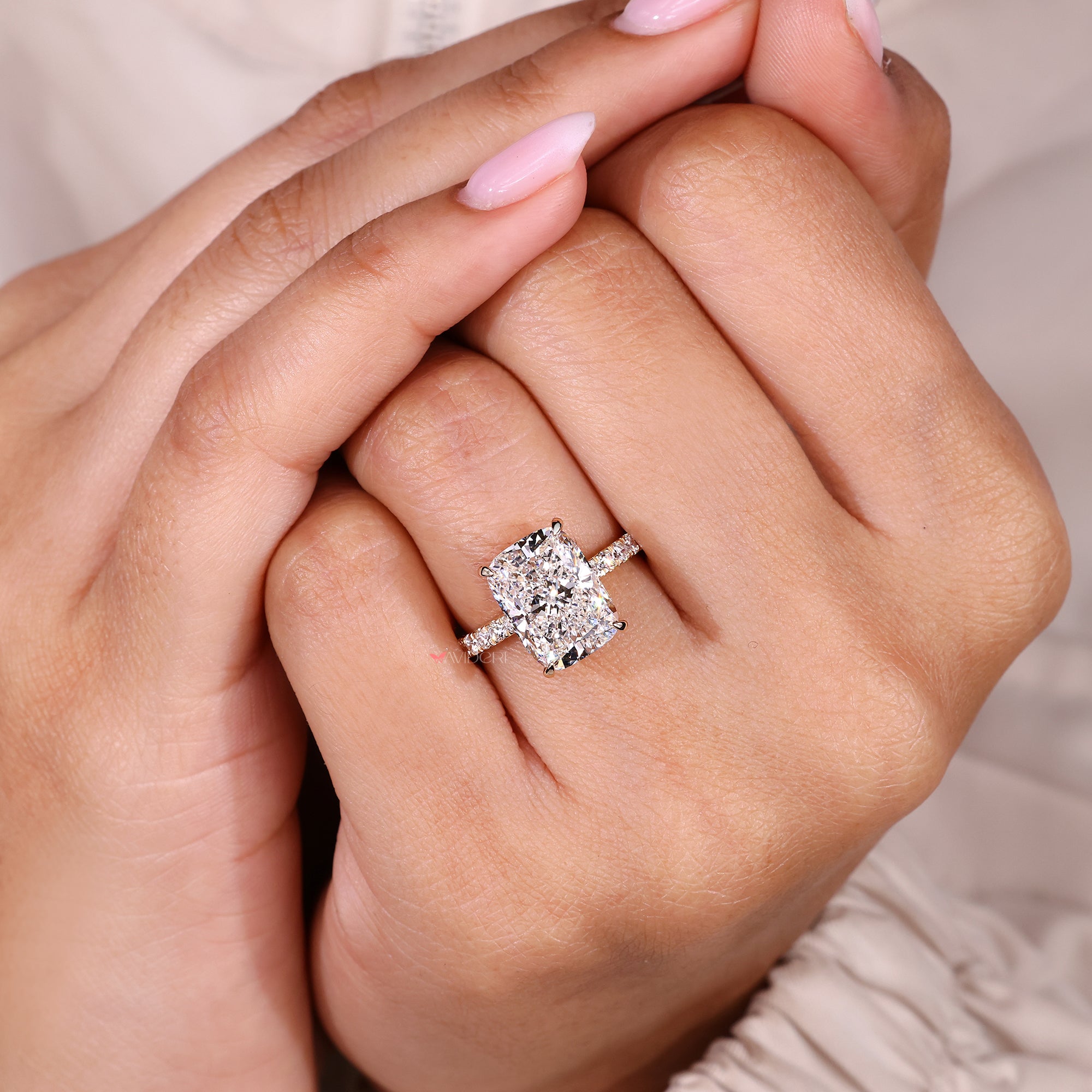 Cushion cut diamond engagement ring with pave band.
