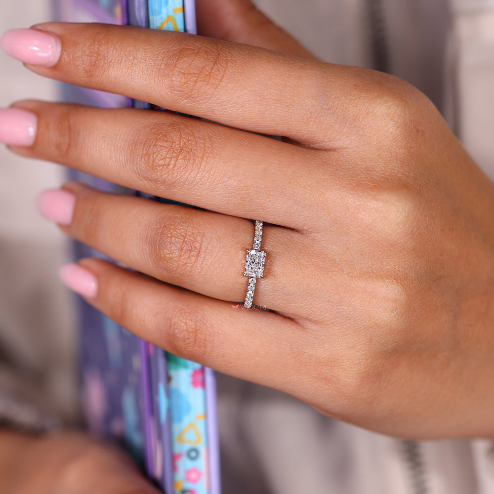 Radiant cut ring with pave band and round diamonds.
