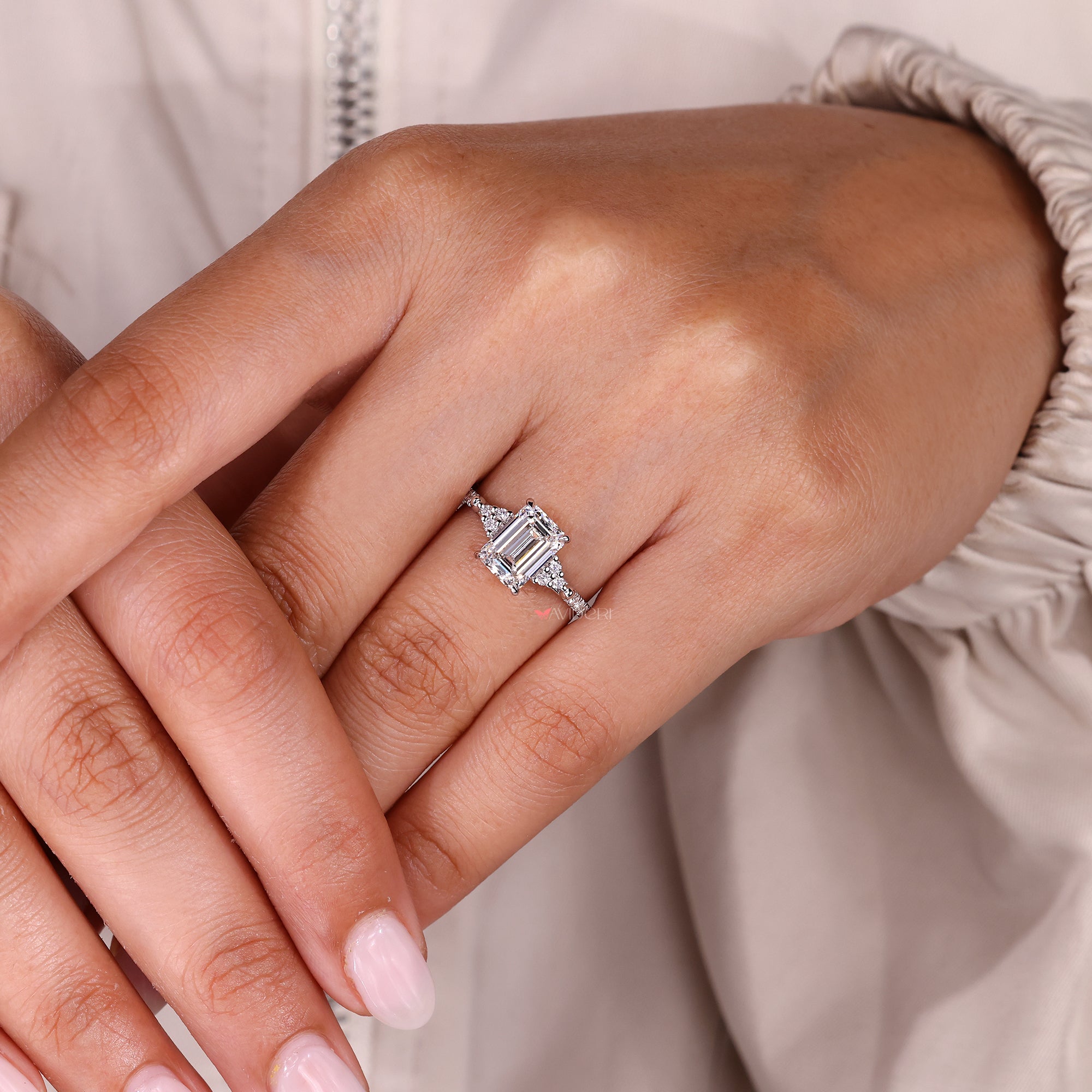 Emerald cut diamond ring with four claw prongs.
