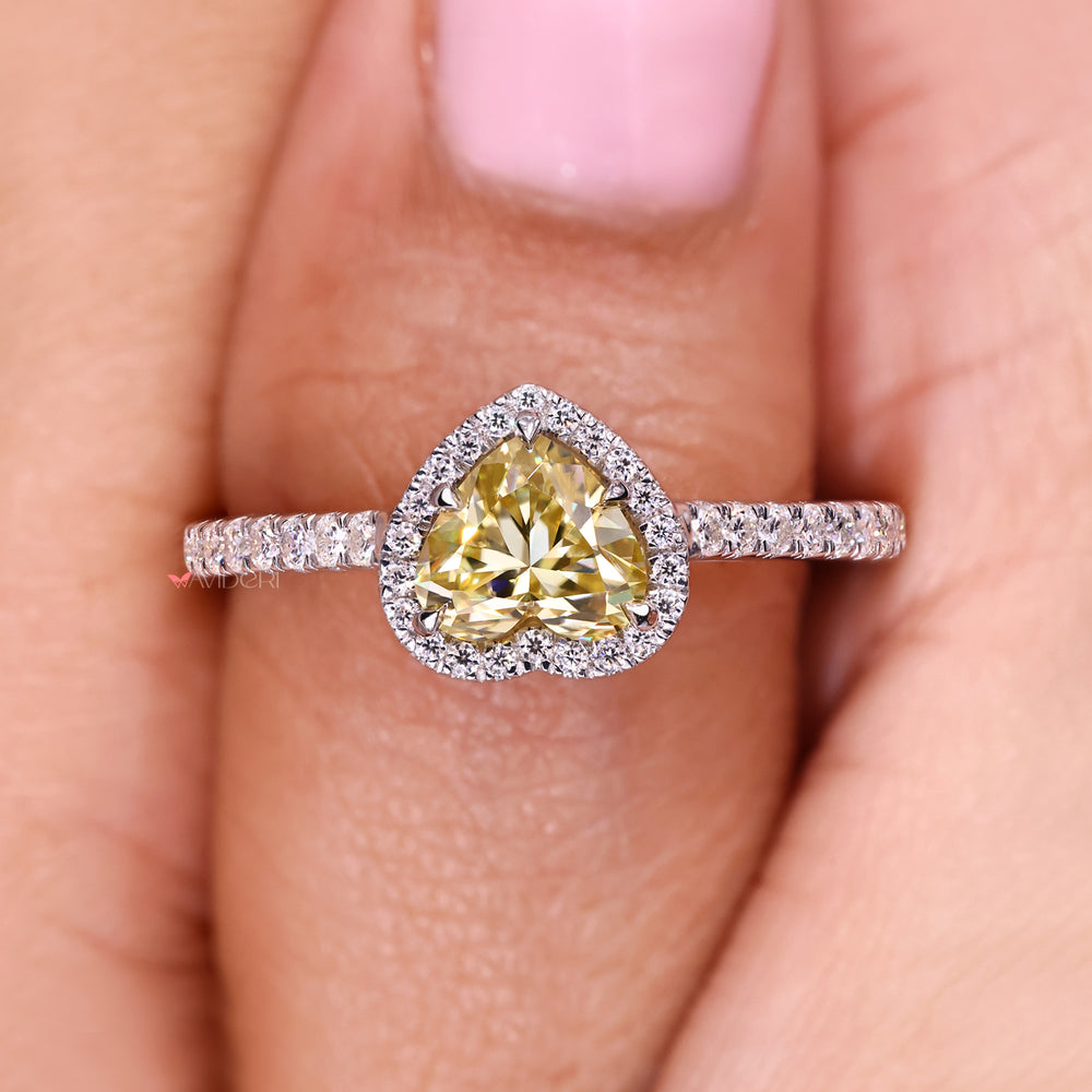 Heart cut moissanite ring with round halo accents.