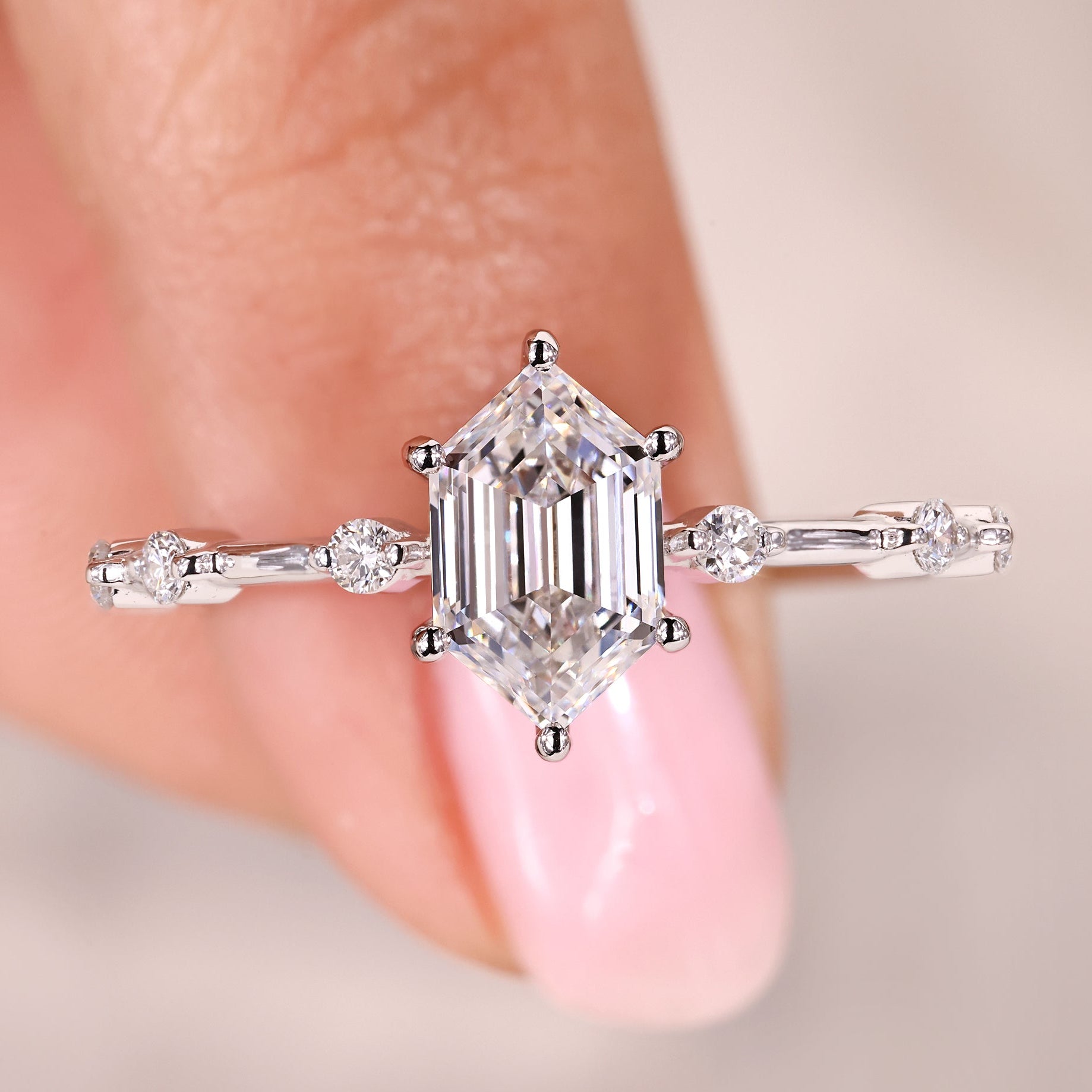 Hexagon step cut diamond ring with distance pave setting.