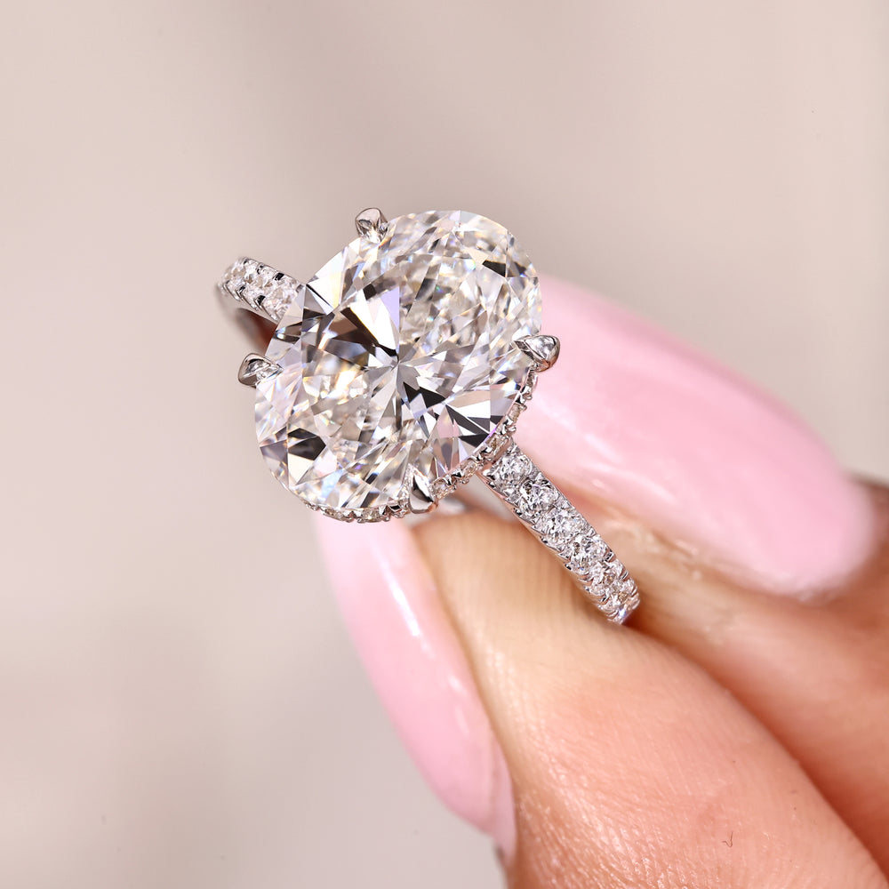 Oval diamond engagement ring with hidden halo and pave style.