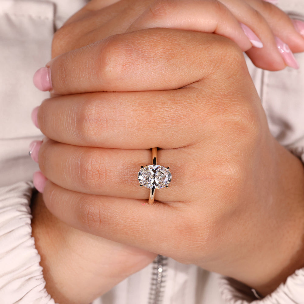 Oval diamond set in a yellow gold diamond ring for a luxurious finish.
